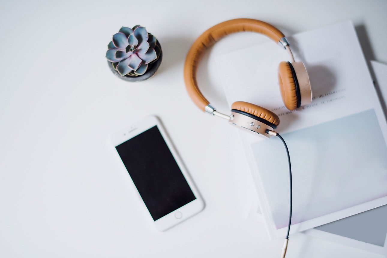Mesa con móvil, auriculares y cuaderno, lista para una sesión online