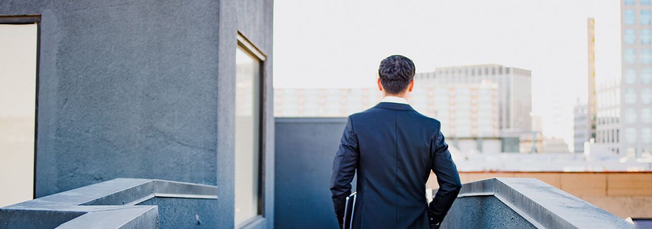 Directivo observando la ciudad desde una terraza de oficinas