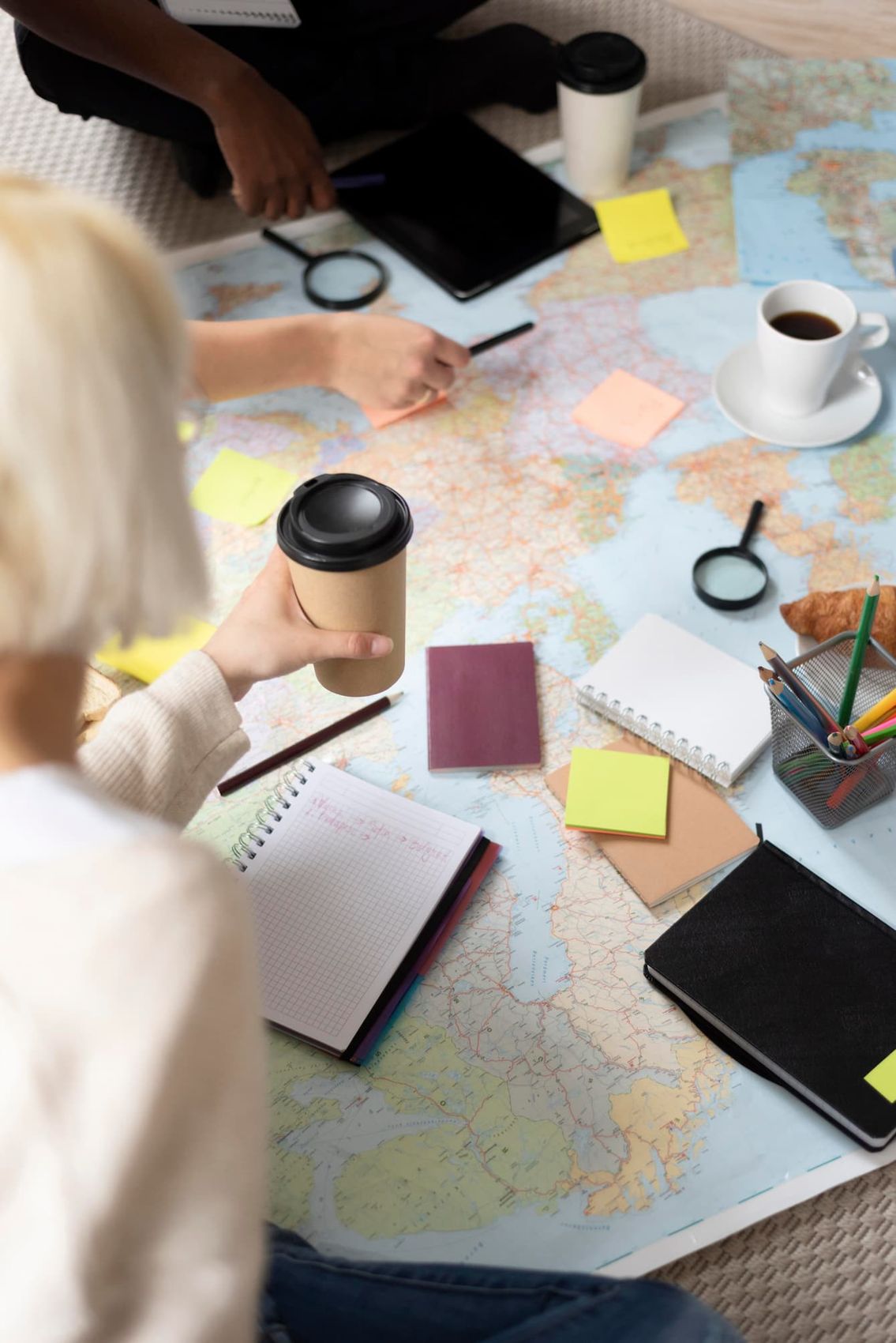 Equipo trabajando alrededor de una mesa con mapas y notas