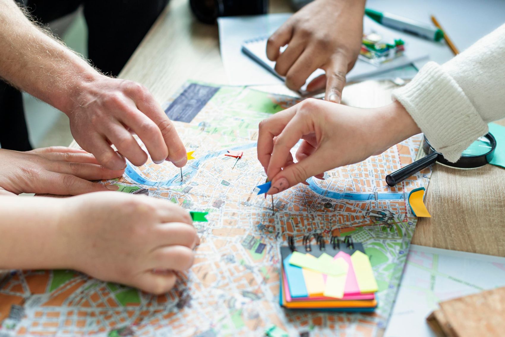 Manos de un equipo trabajando juntas sobre un mapa