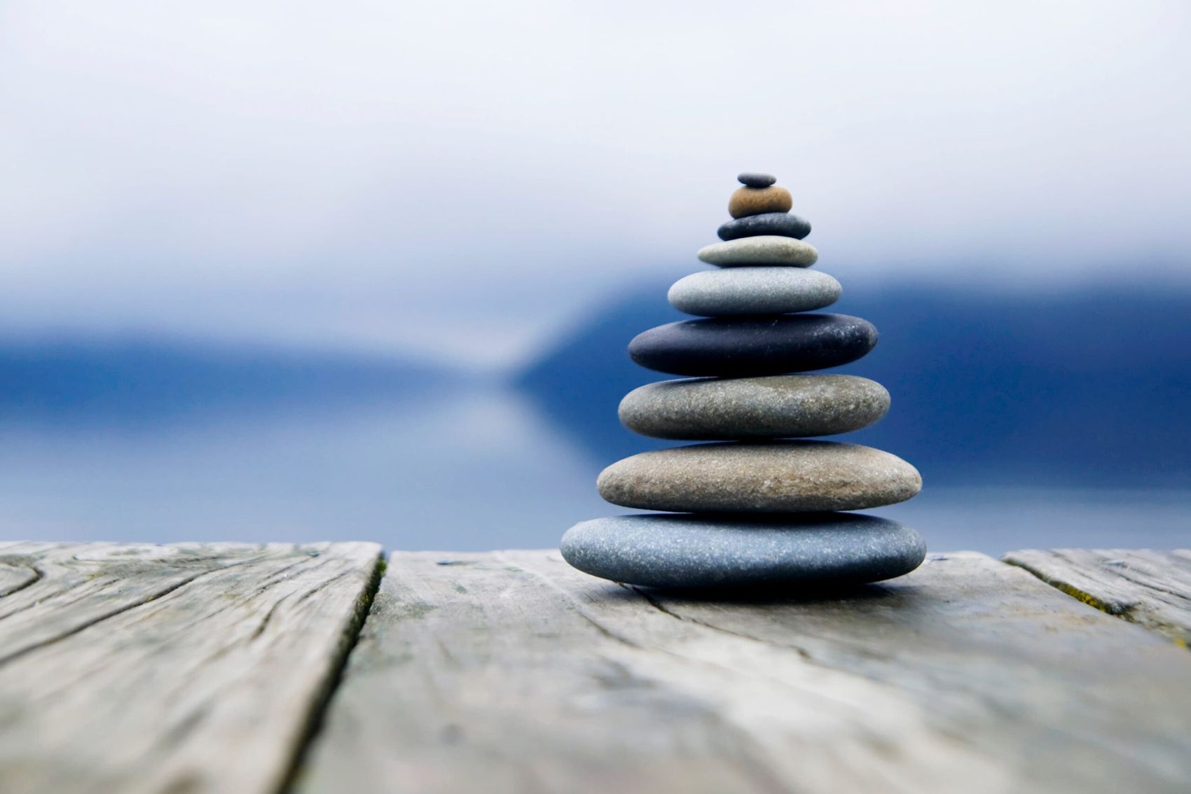 Piedras apiladas en equilibrio frente a un lago