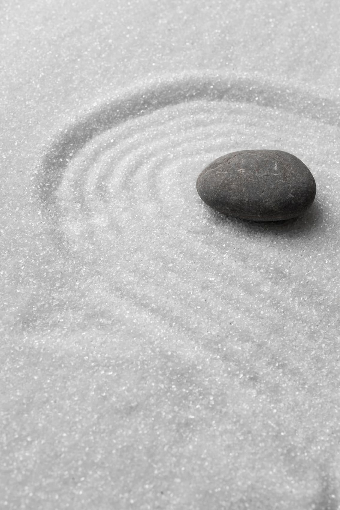 Piedra sobre arena rastrillada en círculos