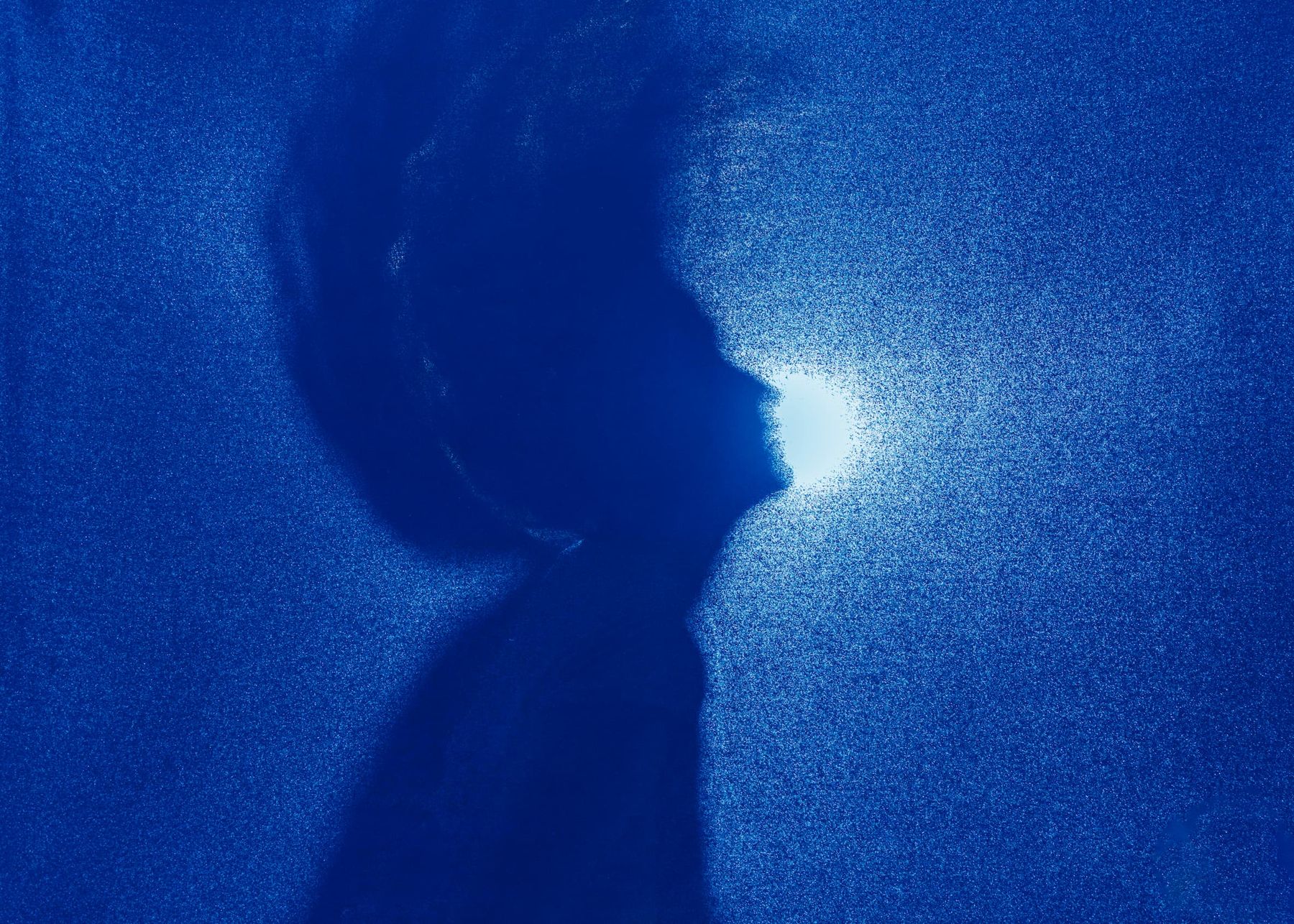 Silueta de perfil iluminada sobre fondo azul